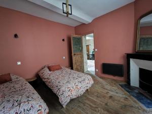 a bedroom with two beds and a fireplace and a tv at L'appart de Léo et Soso in Bayeux