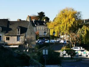 a street in a small town with cars parked at L'appart de Léo et Soso in Bayeux