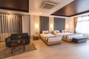 a hotel room with two beds and a couch at Lavie Residence and Spa in Kathmandu
