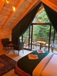 ein Schlafzimmer mit einem Bett und einem großen Fenster in der Unterkunft Hoşdere Suit in Çamlıhemşin