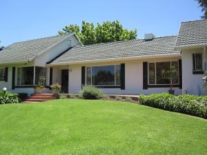 a house with a green lawn in front of it at The Pecan Tree Guesthouse in Johannesburg