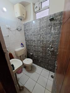 a small bathroom with a toilet and a shower at Private room with Sky Garden in Green Bacchus by Walias in Gurgaon