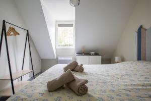 a bedroom with a bed with pillows on it at Cottage Opale in Stella-Plage