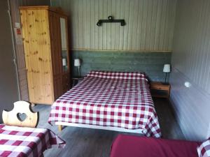 a room with a bed with a checkeredkered blanket at Hôtel du Lac des Confins in La Clusaz