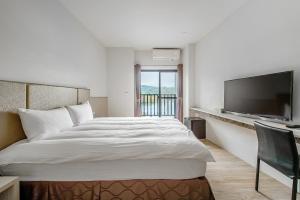 a bedroom with a large bed and a flat screen tv at Sun Moon Lake I Love You in Yuchi +60 photos