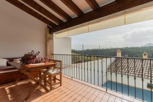 d'un balcon avec une table et une vue sur la piscine. dans l'établissement Casa Rural El Abuelo Luis, à Molinicos