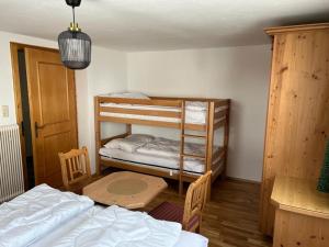 sypialnia z 2 łóżkami piętrowymi i stołem w obiekcie Chasetta Zum Sigrist w mieście Galtür