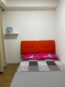 a bed with an orange headboard in a room at The Cozy@Southville, Bangi (Netflix/Disney+/Pool) in Kampong Tangkas