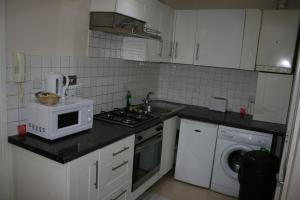 a kitchen with a white stove top oven and white cabinets at Marble Arch Flats in London