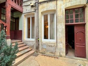 ein altes Gebäude mit einer roten Tür und einer Treppe in der Unterkunft Le boudoir de Clem in Chalon-sur-Saône