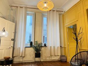 um quarto com cortinas brancas e uma janela em Le boudoir de Clem em Chalon-sur-Saône