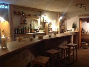 a bar with stools and bottles on the wall at Hôtel du Lac des Confins in La Clusaz