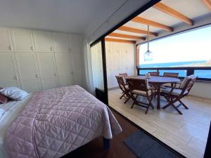 1 dormitorio con 1 cama, mesa y sillas en 100 m2 Penthouse on the beach., en Patalavaca