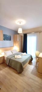 The Central Villa - Kassiopi Corfu Villas في كاسيوبي: غرفة نوم عليها سرير وفوط