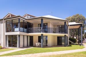 a large house with large windows and a lawn at 5@CapeView, beachfront Geographe Bay in Busselton