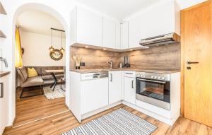 Una cocina con gabinetes blancos y una sala de estar. en Ferienwohnung- Neustift I St, en Neustift im Stubaital