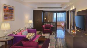 a living room with purple furniture and a flat screen tv at Fortune Park, Haridwar - Member ITC's Hotel Group in Haridwār