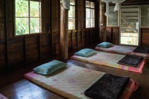 a room with four beds in it with windows at Art House at Chiangdao - Waterlily House in Chiang Dao +13 photos