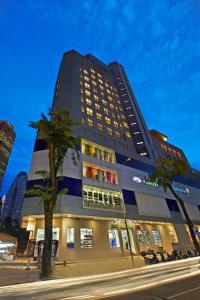 a tall building with a palm tree in front of it at Metrostar Hotel Kuala Lumpur in Kuala Lumpur
