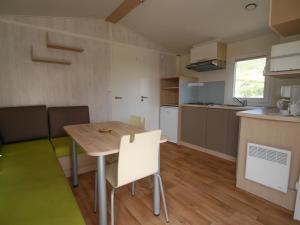 eine Küche und ein Esszimmer mit einem Tisch und Stühlen in der Unterkunft VAL ST GEORGES in Saint-Georges-de-Luzençon