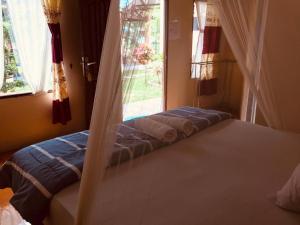 a bed in a bedroom with a window at Thomas' Retreat Bukit Lawang in Bukit Lawang