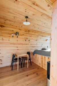 a room with a table and a bed in a cabin at La cabane de la Ferme du Ry in Sorinnes