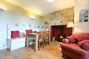 a living room with a table and a fireplace at Farne View Cottage in Seahouses