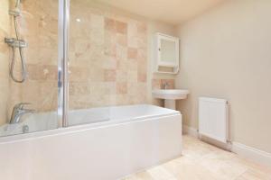 a bathroom with a shower and a tub and a sink at Farne View Cottage in Seahouses +19 photos