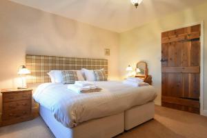 a bedroom with a large bed with towels on it at Farne View Cottage in Seahouses