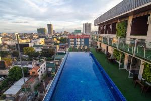 a swimming pool on the roof of a building at A Capsule Hostel in Manila