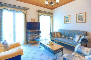 a living room with a blue couch and a table at Theophilos Dio in Ágios Stéfanos