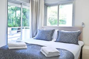 1 dormitorio con 1 cama con almohadas y ventanas azules en Friendly 2BR in Gordon area by HolyGuest, en Tel Aviv