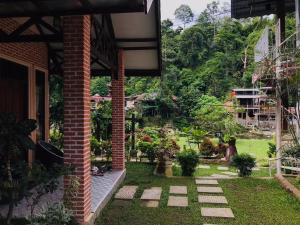 un patio de una casa con jardín en Thomas' Retreat Bukit Lawang, en Bukit Lawang