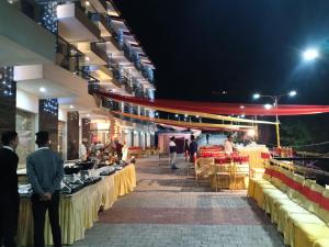 un mercado con mesas y gente caminando por la noche en Wood Creek Resort & Spa Kasauli en Kasauli