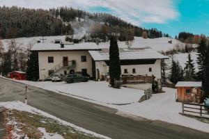 una casa al lado de una carretera cubierta de nieve en Bio-Bauernhof Zirmhof, en Fendels