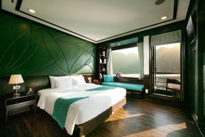a bedroom with a large bed and a green wall at Peony Cruises in Ha Long