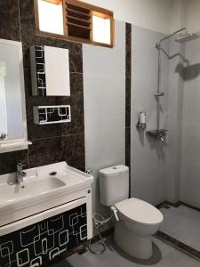 a bathroom with a toilet and a sink at Thomas' Retreat Bukit Lawang in Bukit Lawang