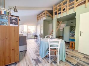 a room with a table and a loft bed at Gite l'Odonate, partage des eaux in L'Isle-sur-la-Sorgue