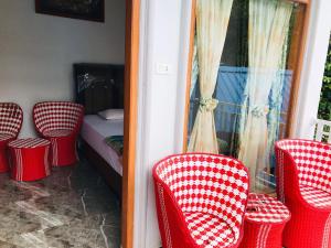 a room with red chairs and a bed and a window at Thomas' Retreat Bukit Lawang in Bukit Lawang