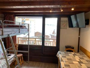 a room with a bunk bed and a balcony at Residence Le Lac Blanc in Val Thorens