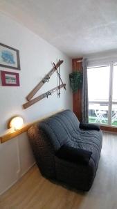 a living room with a couch and a large window at Studio Montagne à la Pierre St Martin in Arette