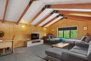 a living room with two couches and a tv at The Barn - Waihi Holiday Home in Waihi