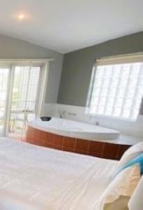 a bedroom with a bed and a bath tub at Waves Luxury Suites in Port Campbell