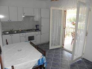 a kitchen with a table and an open door at Apartment in Lopar with sea view, terrace, washing machine 593-2 in Lopar