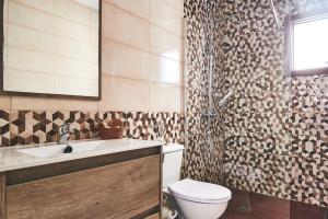 a bathroom with a toilet and a sink and a shower at Casa Mar adentro in La Santa +29 photos