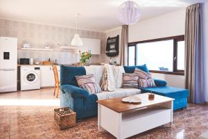 sala de estar con sofá azul y mesa en Casa Mar adentro en La Santa