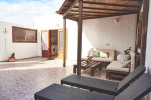 un patio con sofá, mesa y sillas en Casa Mar adentro en La Santa