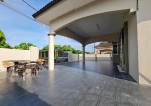 una casa con patio con mesa y sillas en Air-home No 9 Kampung Boyan, 4BR, 9pax, Netflix, en Taiping