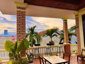 a balcony with a table and chairs and palm trees at Hidden Hue Homestay in Hue