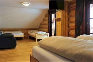 a hotel room with two beds and a television at Zrub pod Poľanou in Detvianska Huta
